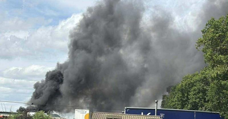 Large fire breaks out on field near industrial site