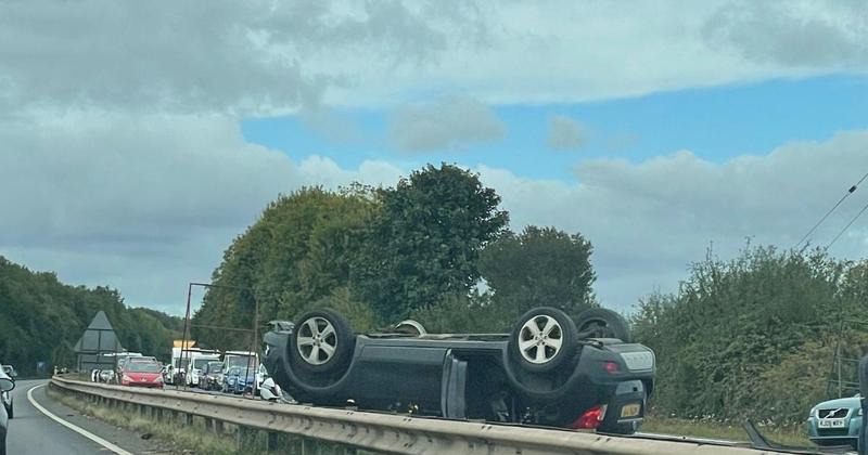A11 closed in both directions after car rolls onto roof