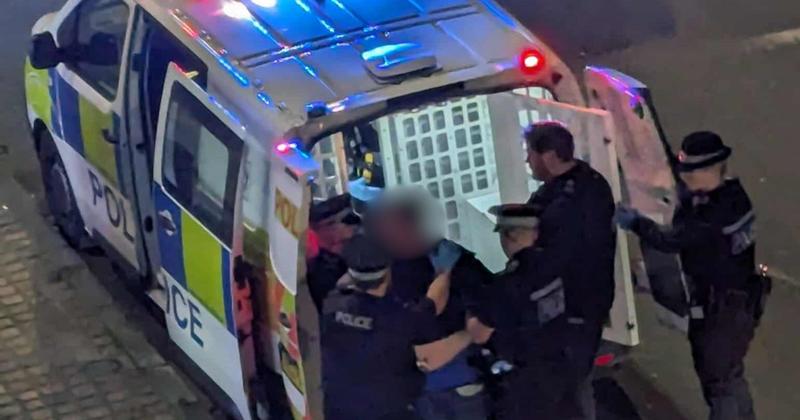 Man resists being bundled into police van after racist threats made Man resists being bundled into police van after racist threats made