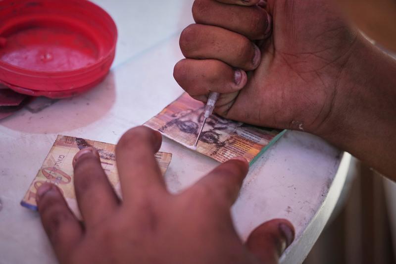 Gazan woman undertakes tiring task of repairing enclave’s tattered banknotes